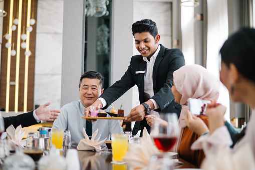 Asian business people enjoy food in restaurant.