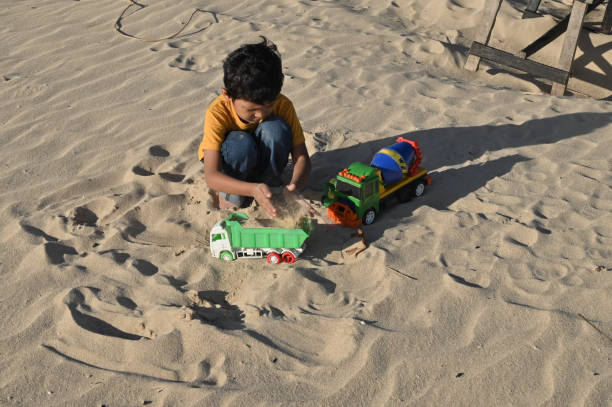 Asian Boy Playing Toys With Sand