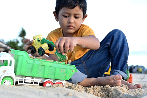 Asian Boy Playing Toys With Sand