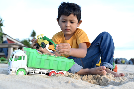 Asian Boy Playing Toys With Sand