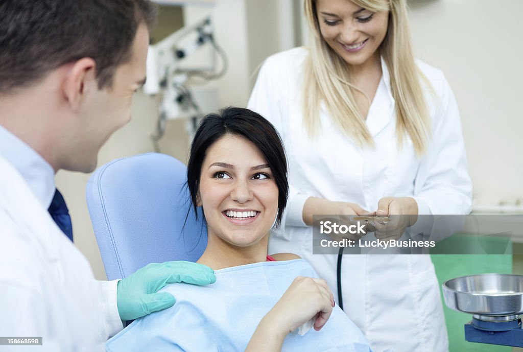 Dental practice Male dentist, his assistant and female patient in dental practice Dentist Stock Photo