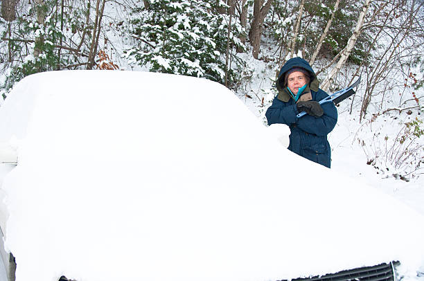 istock Woman shivering by a snow-covered car 158670359