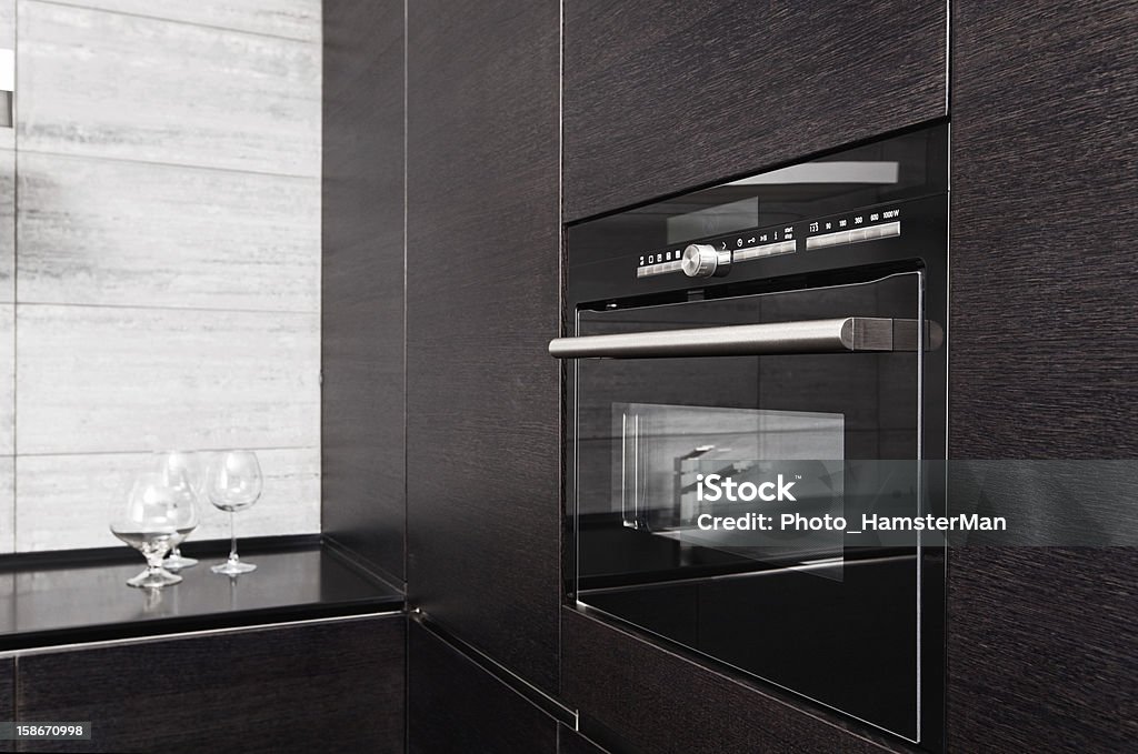 Part of black hardwood kitchen with build-in microwave oven Drawer Stock Photo