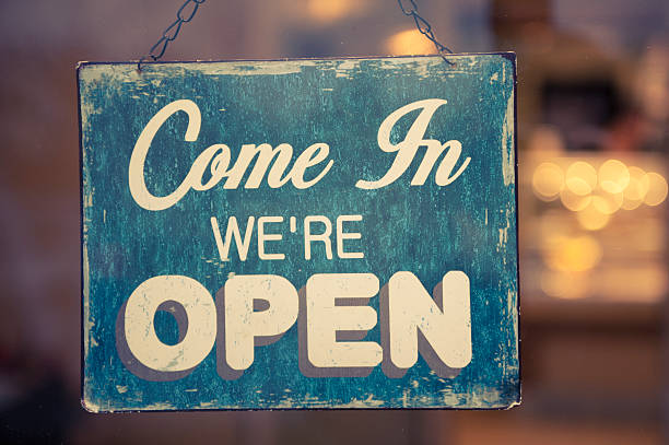 Sign hanging from a chain that says Come In we're Open stock photo