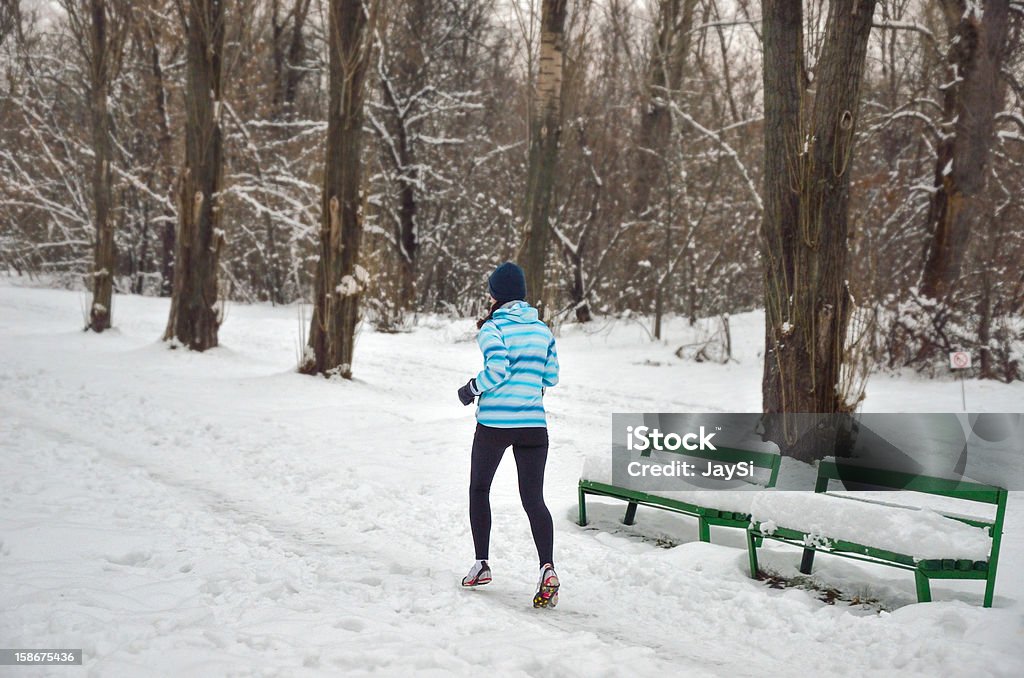 Winter run, woman in snowy park Active happy woman runner jogging outdoors in snowy park in winter, healthy lifestyle, sport and running concept Active Lifestyle Stock Photo