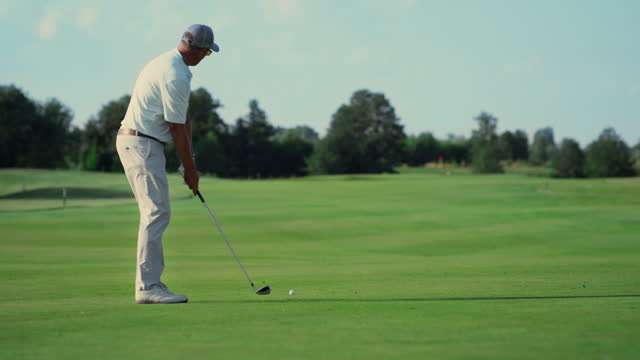 Professional athlete playing golf outdoors. Man walking golfing course in summer
