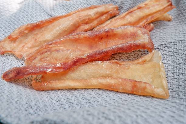 istock Plate of dry fish pieces on a gray blanket 1586855620