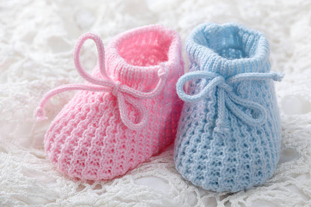 Blue and pink baby booties Blue and pink baby booties on white background baby booties stock pictures, royalty-free photos & images