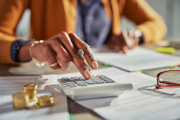 Black woman hand calculating taxes stock photo
