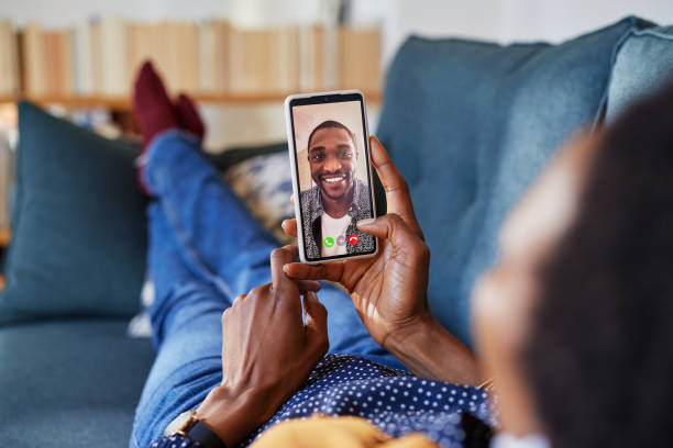 istock Woman doing video call with her black boyfriend lying on sofa 1586917852