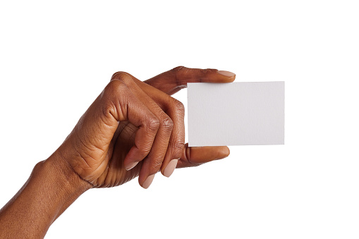 Close up of black woman hand holding blank placard against white background. African american girl hand showing blank visiting card isolated. Female hand showing business card.