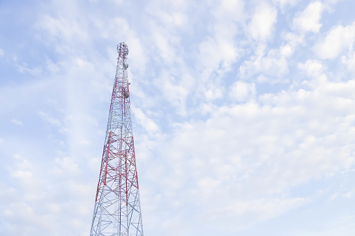 Telecommunication towers include of radio microwave and television antenna system with cloud blue sky and sun ray. Base Transceiver Station Antenna tower, low angle view. Empty blank copy text space.