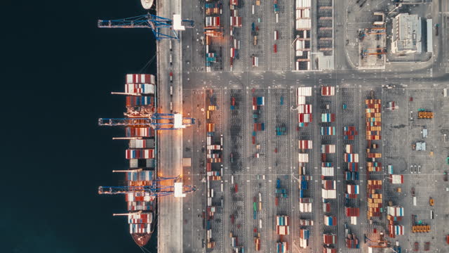 Container ship in export and import business and logistics. Shipping cargo to harbor by crane. Water transport International. Aerial view and top view