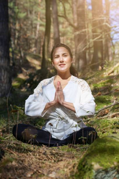 istock Symbol image: Young woman doing foresth bathin (Shnrin Yoku), natural therapy from Japan (Model released) 1587005076