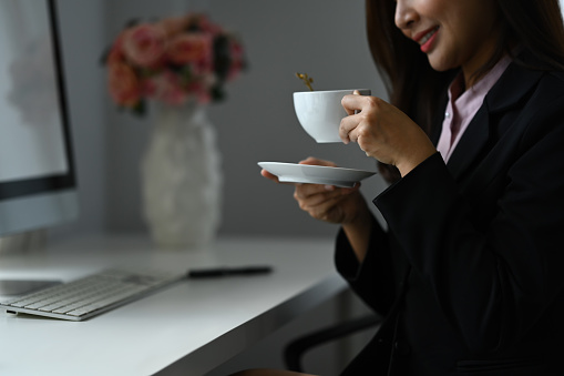 Relaxed woman drinking tea, enjoying her leisure time during her work break.