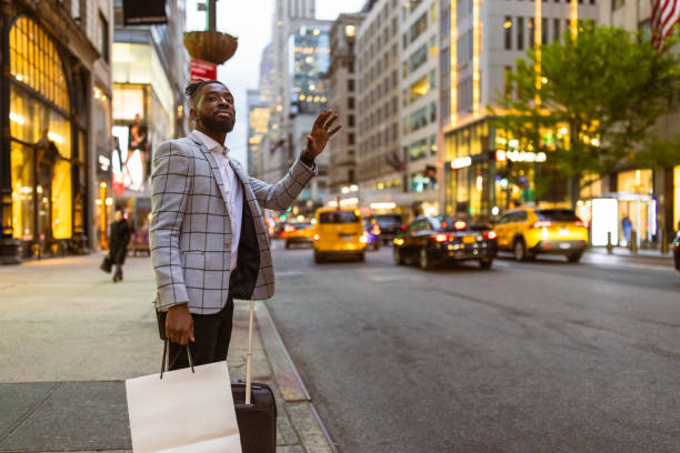 Affluent black businessman on a trip to NYC, shopping, calling a cab stock photo