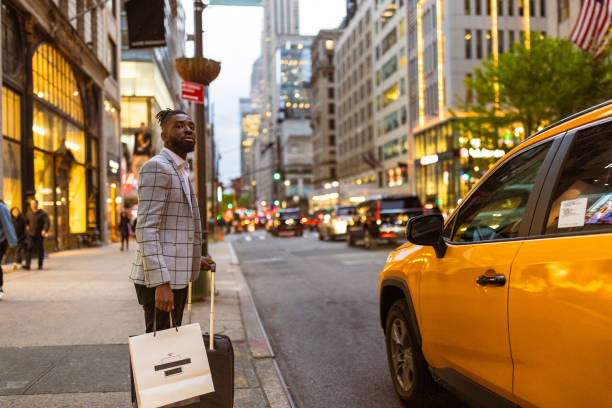 istock Affluent black businessman on a trip to NYC, shopping, calling a cab 1587014332