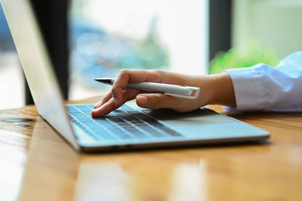 istock Side view of female worker hand typing on laptop, searching information, browsing internet, working online. 1587015389