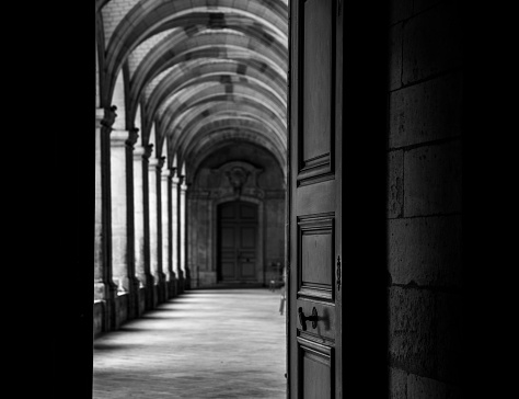 Assisi, Umbria, Italy, August 30 -- A typical scene of daily life in Assisi with a Franciscan friar walking under the colonnade of the Basilica di Santa Maria degli Angeli, in the Assisi municipality, in Umbria. Image in high definition quality.