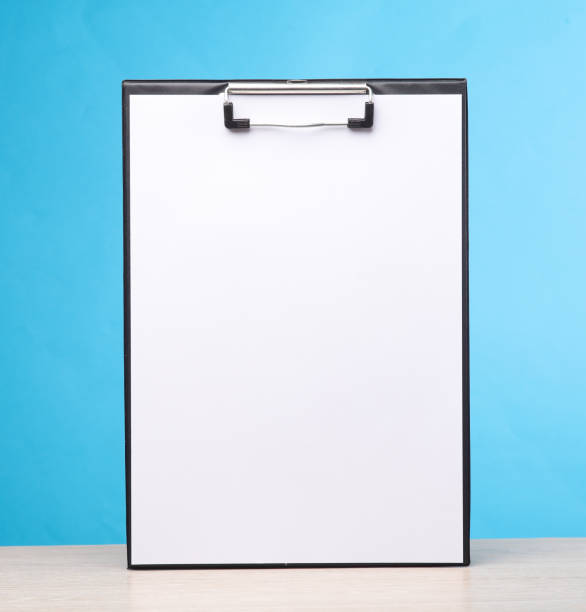 White empty clipboard on the table, blue background. Template for design stock photo
