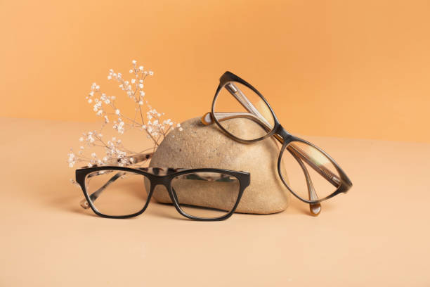 istock Nature stone with eyeglasses on colored background. Optical store, vision test, stylish glasses concept 1587027922