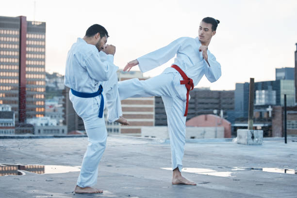 istock Men, fight and kick in karate class, training and speed with sparring partner, workout and morning on city rooftop. Martial arts team, contest and fitness with block for exercise, coaching or sports 1587037833