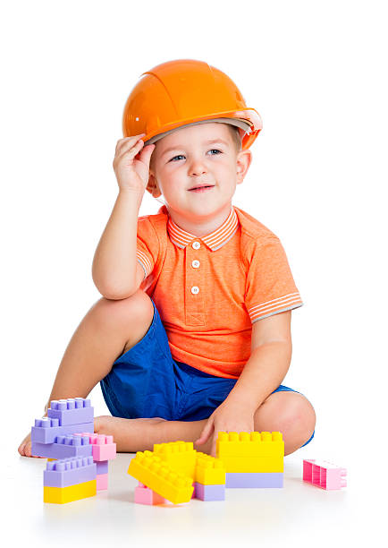 istock cheerful child boy weared hard hat playing with building blocks 158706314
