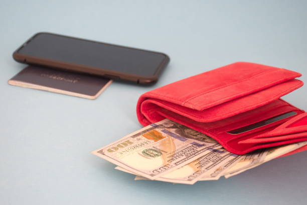 istock Red wallet with dollar banknotes, mobile phone and passport 1587069381