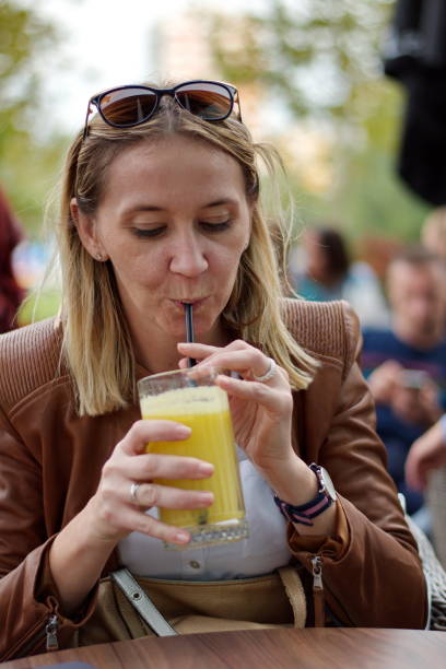 istock Woman sitting in the restaurant drinking juice 1587069925