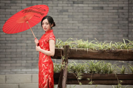 The woman wearing a qipao umbrella