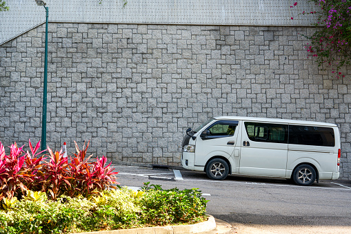 A white classic van parked on the half slope of the street in Hong Kong