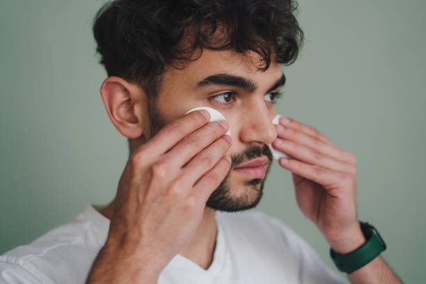 istock Man applying eye patches on face 1587135484