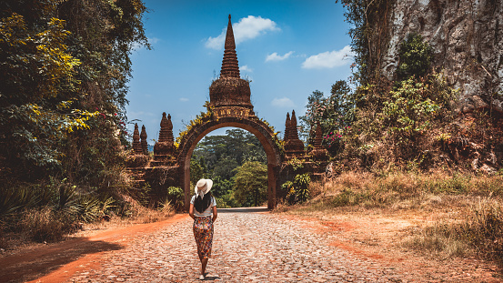 Young Caucasian woman standing near the old door in Wat Pho temple, Bangkok