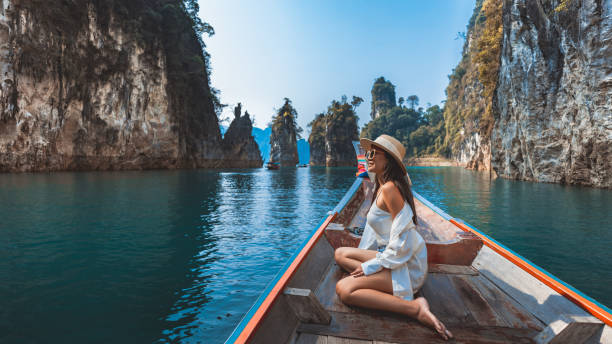 traveler asian woman relax and travel on thai longtail boat in ratchaprapha dam at khao sok national park surat thani thailand - luxe fotos stockfoto's en -beelden