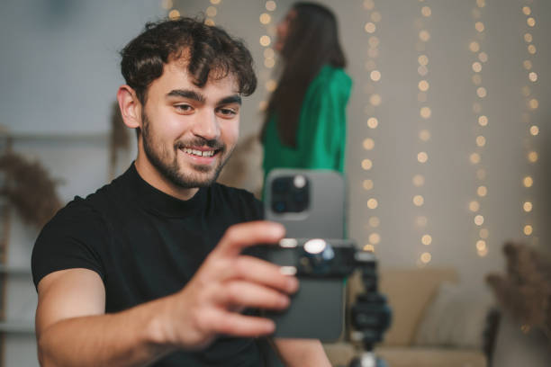 istock Cheerful young man with photo camera 1587146323