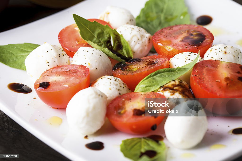 Caprese salad Caprese: cherry tomato, mozzarella balls and basil leaves Balsamic Vinegar Stock Photo