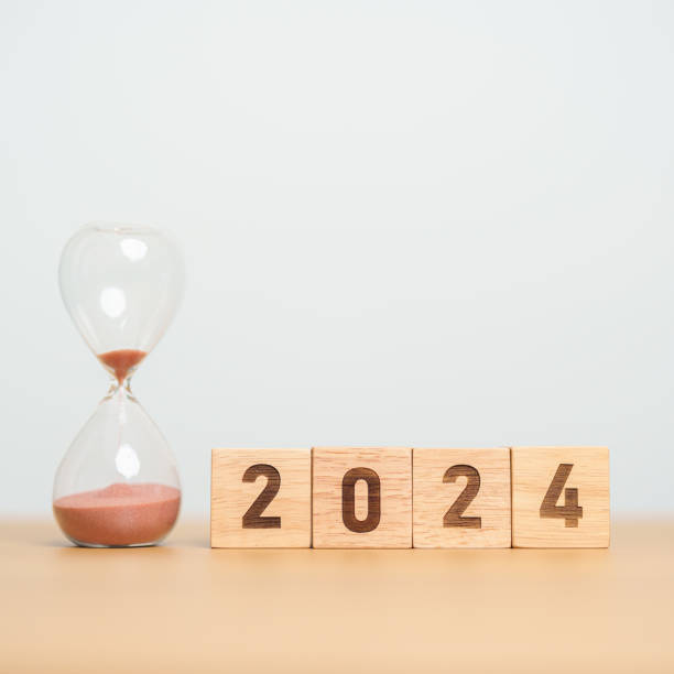 istock 2024 text with hourglass on table. Resolution, time, plan, goal, motivation, reboot, countdown  and New Year holiday concepts 1587179649