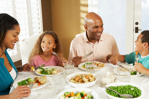 Family Enjoying Meal At Home Smiling