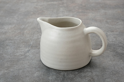 Small ceramic jug or pitcher with handle.