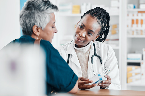 Pills, pharmacy or old woman consulting with a pharmacist for retail healthcare treatment information. Questions, trust or black woman helping a senior woman shopping for medicine or medical drugs