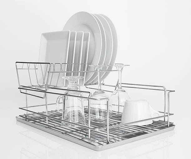 White dishes drying on metal dish rack White dishes and wine glasses drying on a metal dish rack. plate rack stock pictures, royalty-free photos & images