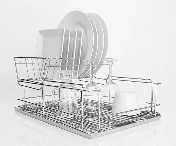 Photo of White dishes drying on metal dish rack