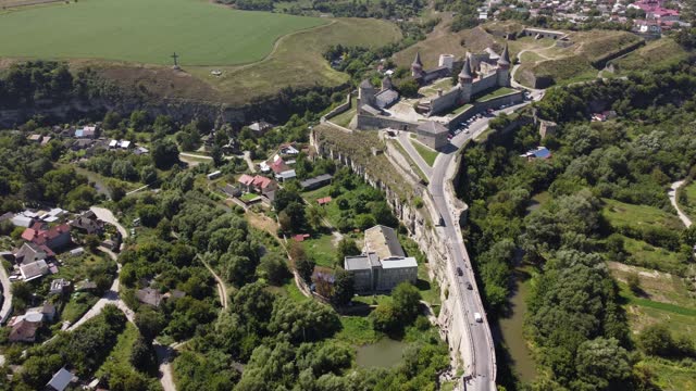 Aerial drone high view of city of Kamenets-Podolsky in Ukraine. Kamianets-Podilskyi cityscape with concrete bridge through green canyon to castle. Flying over the historical old town in Europe