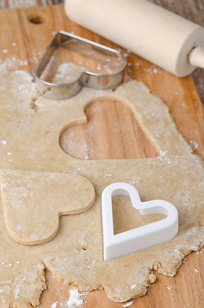 istock Cookie dough rolled out with heart shapes cut into it 158721880
