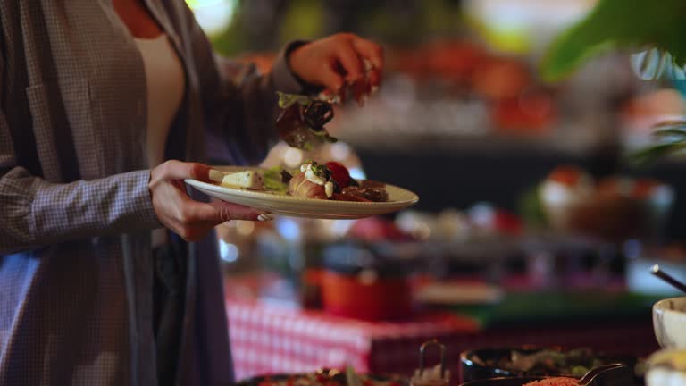 Young woman takes breakfast on a plate, iftar time in Ramadan, food service for iftar, woman serving food from open buffet in restaurant, getting food on her plate