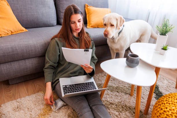 Woman doing paperwork while working from home with her pet dog
