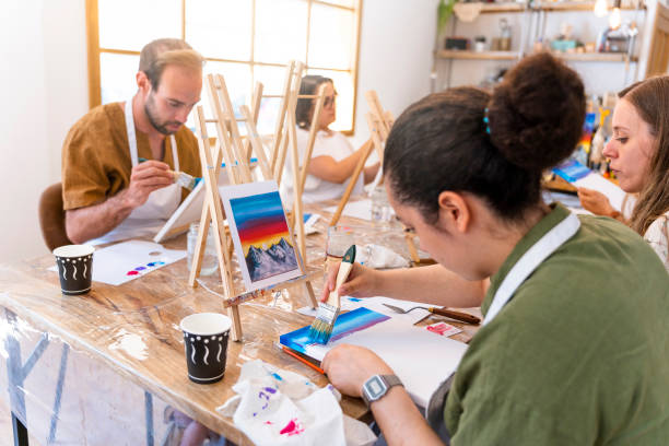 istock Art and Wine Workshop. Friends painting while tasting different wines. 1587234587