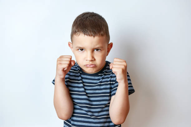 istock Little boy in a boxing rack with a stern expression. 1587237816