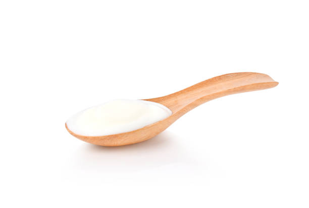 istock yogurt in wooden spoon isolated on white background 1587249072