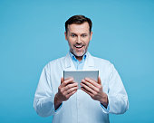 Portrait of surprised male doctor with digital tablet